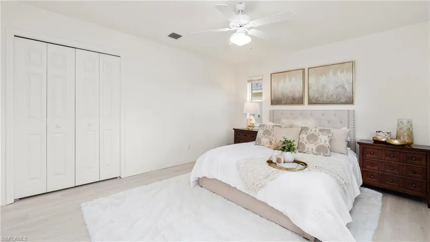 Bedroom featuring light wood-style flooring, a ceiling fan, and a closet