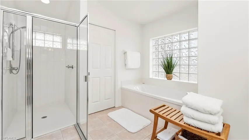 Full bath with plenty of natural light, a garden tub, a stall shower, and light tile patterned floors