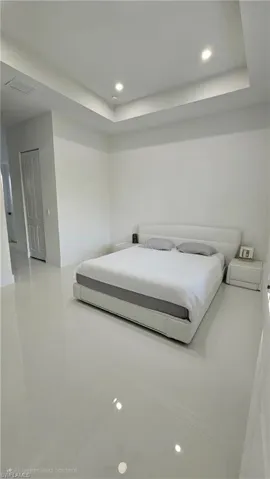 Bedroom featuring recessed lighting, a tray ceiling, and tile patterned floors