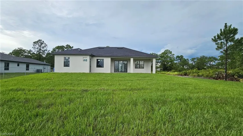 Rear view of house with stucco siding and a patio