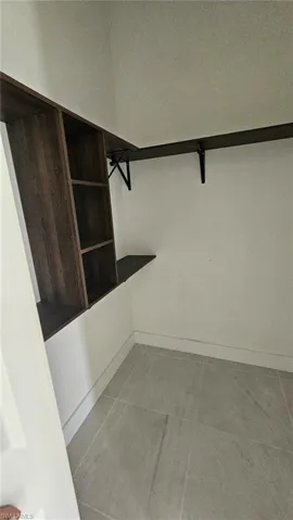 Spacious closet with light tile patterned floors