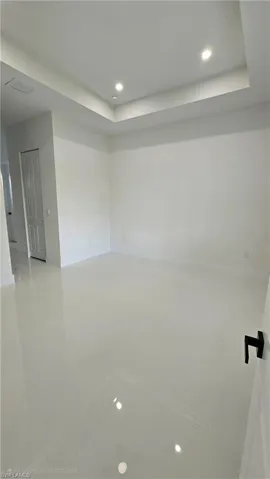 Unfurnished room featuring recessed lighting and a raised ceiling