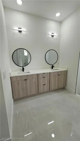 Bathroom with recessed lighting and double vanity