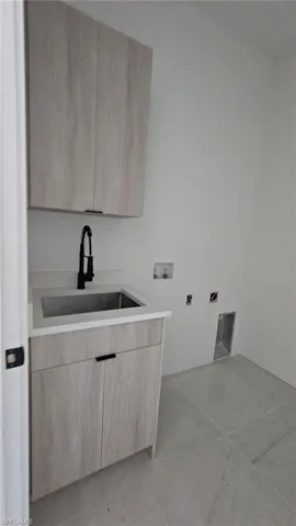 Washroom featuring hookup for a washing machine and cabinet space