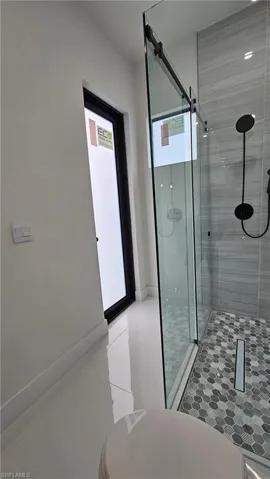 Full bathroom with a shower stall and light tile patterned floors