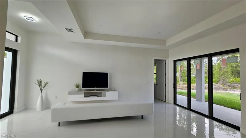 Living room with a tray ceiling and light tile patterned floors