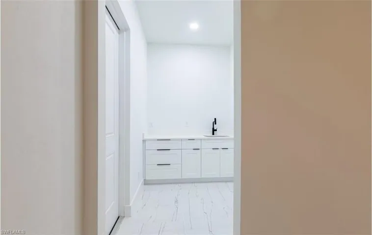 Hallway with recessed lighting and a sink