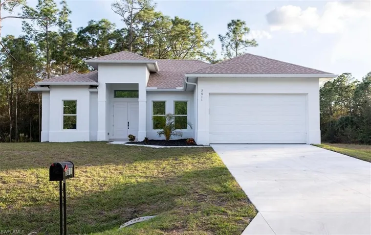 View of front of property with a garage, a front yard, a shingled roof, and driveway