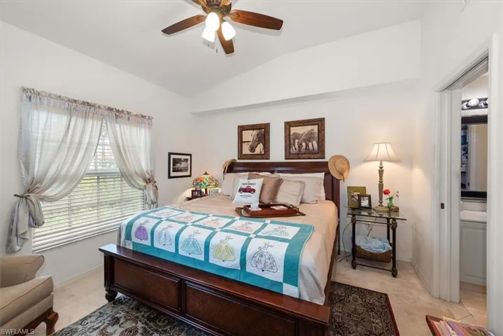 Spacious primary bedroom with a lofted ceiling, ceiling fan, and soft neutral carpeting for a comfortable retreat.