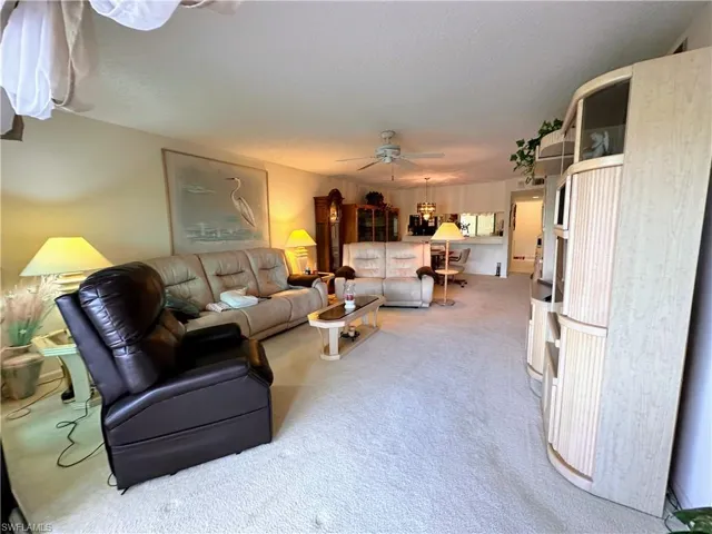 Carpeted living room with ceiling fan