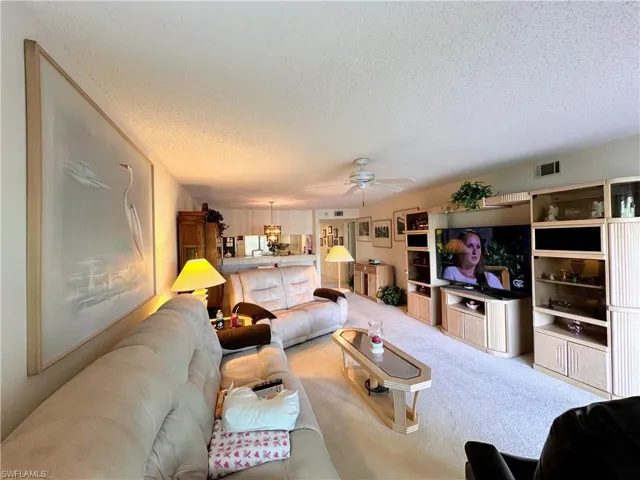 Living room with carpet, and a ceiling fan