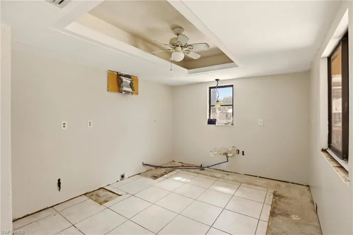 Unfurnished room featuring ceiling fan and a raised ceiling