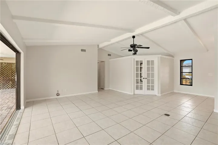 Unfurnished room featuring french doors, ceiling fan, beamed ceiling, and light tile patterned flooring