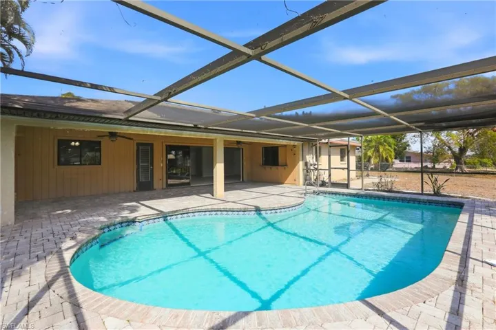 Swimming pool with a sunroom, glass enclosure, and a patio