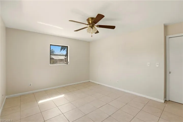 Unfurnished room featuring ceiling fan and light tile patterned floors