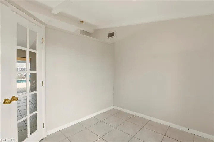 Room with light tile patterned floors and vaulted ceiling
