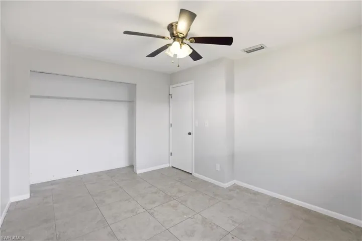 Unfurnished bedroom featuring ceiling fan, a closet, and light tile patterned flooring