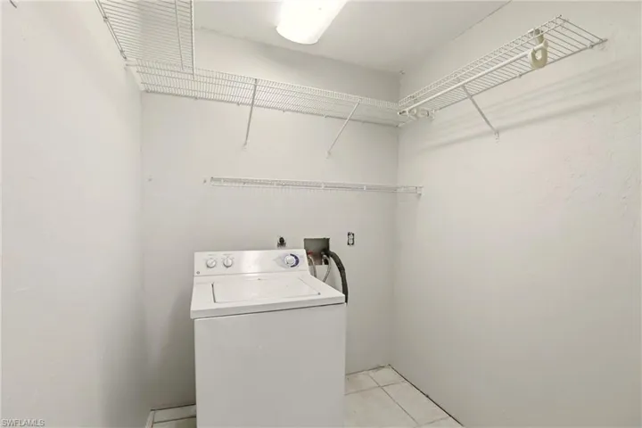 Laundry area with washer / clothes dryer and light tile patterned floors
