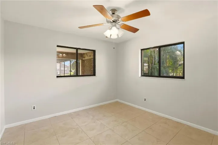 Unfurnished room with ceiling fan and light tile patterned floors