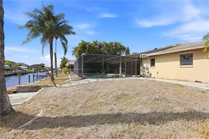 View of yard with a sunroom, a lanai, an outdoor pool, and a water view