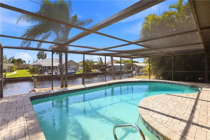 Outdoor pool with a residential view, a sunroom, a lanai, and a water view
