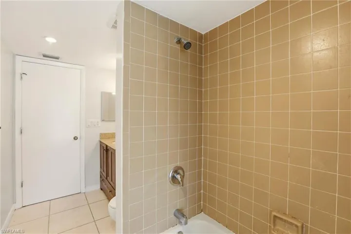 Bathroom with vanity, shower / bath combination, light tile patterned flooring, and recessed lighting