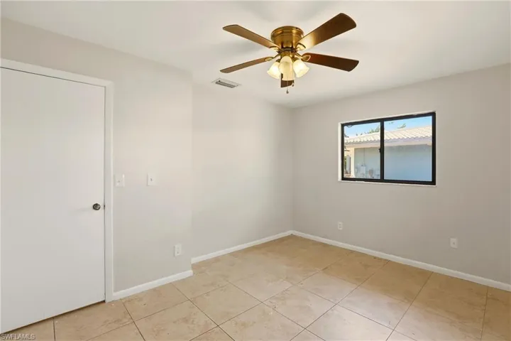 Spare room with ceiling fan and light tile patterned flooring