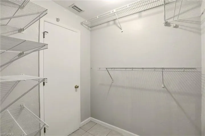 Walk in closet with light tile patterned flooring