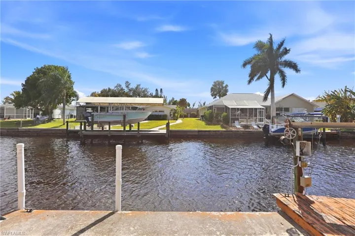 Dock featuring a water view, boat lift, and a residential view