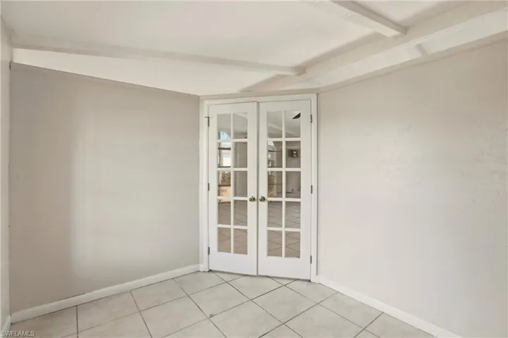 Spare room featuring french doors and light tile patterned floors