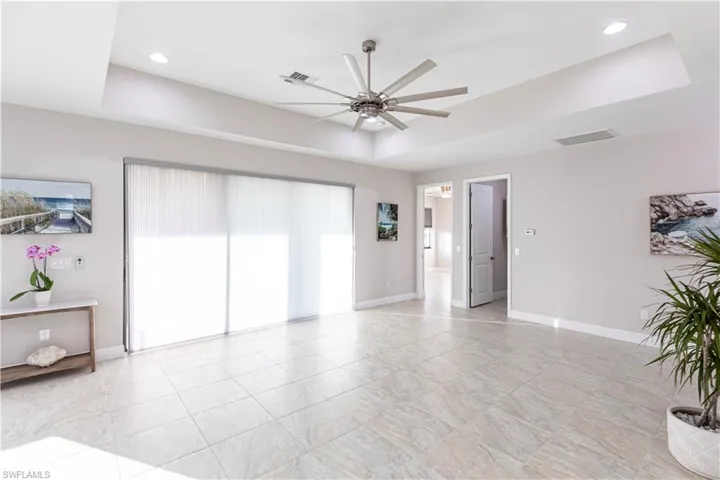 Empty room featuring a raised ceiling and ceiling fan