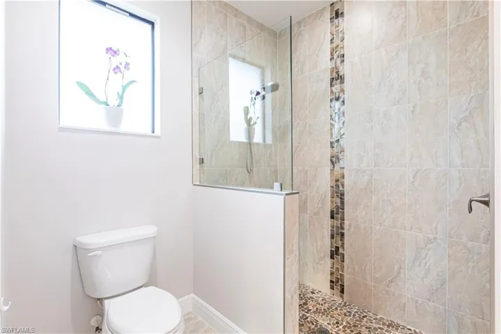 Bathroom with a tile shower and toilet