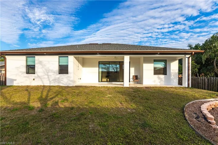 Rear view of property featuring a yard and a patio area