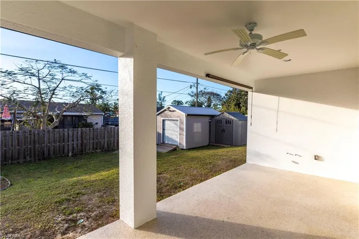 View of patio with ceiling fan and a storage unit