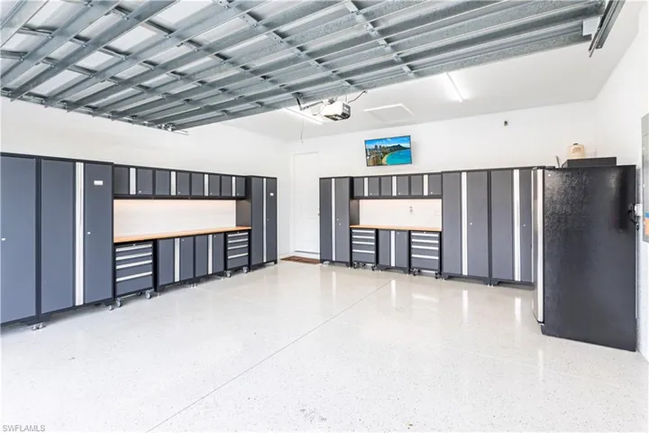 Garage with a garage door opener and stainless steel refrigerator