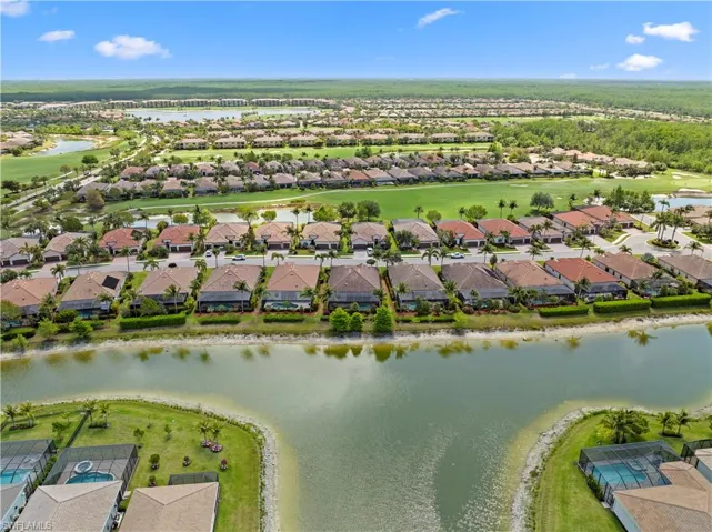 Birds eye view of property with golf course view, a water view, and a residential view