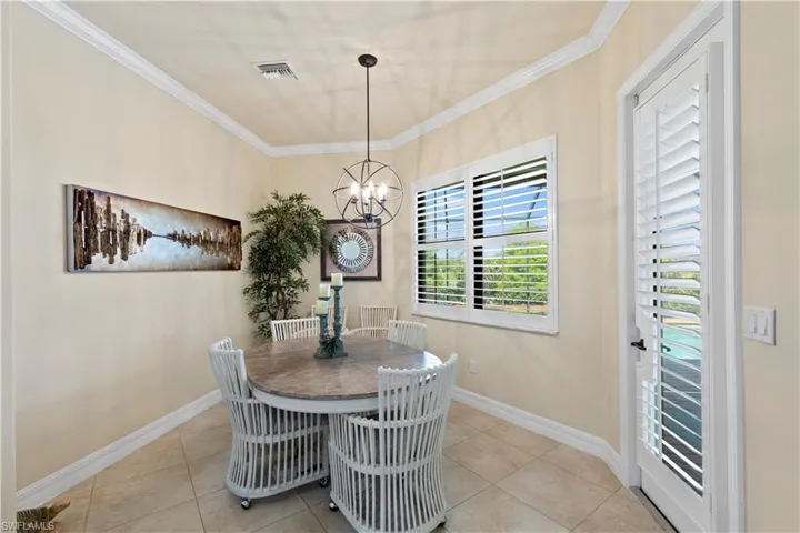 Dining space with an inviting chandelier, 20" tile flooring, baseboards,  and crown molding
