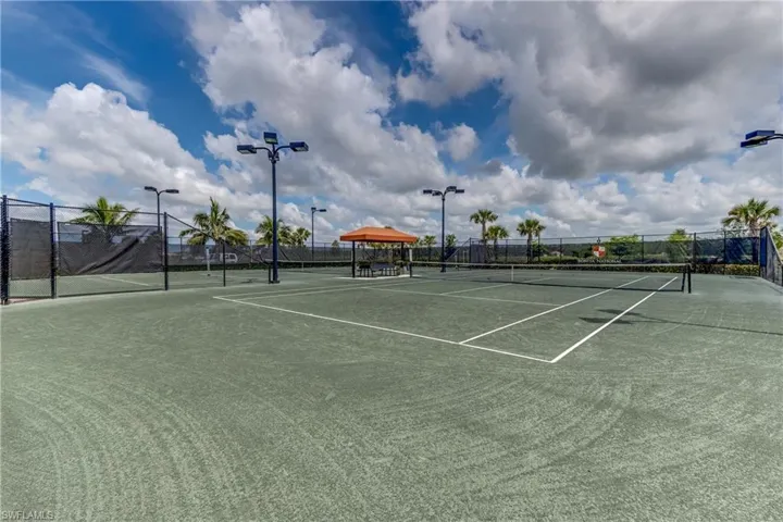 View of tennis court featuring fence