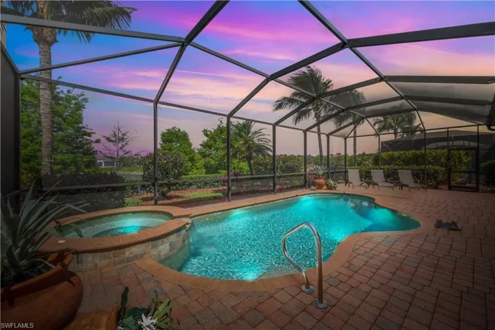 Pool at dusk, pool with connected hot tub, and a patio area