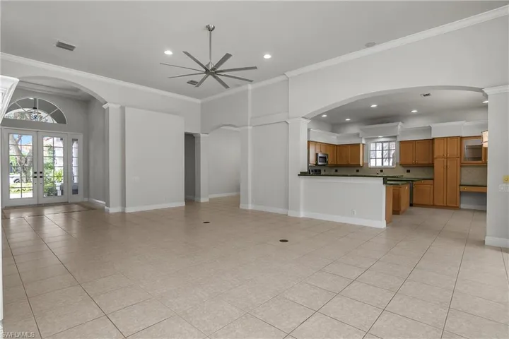 Great room, without furniture, showing open visibility to and from the kitchen.
