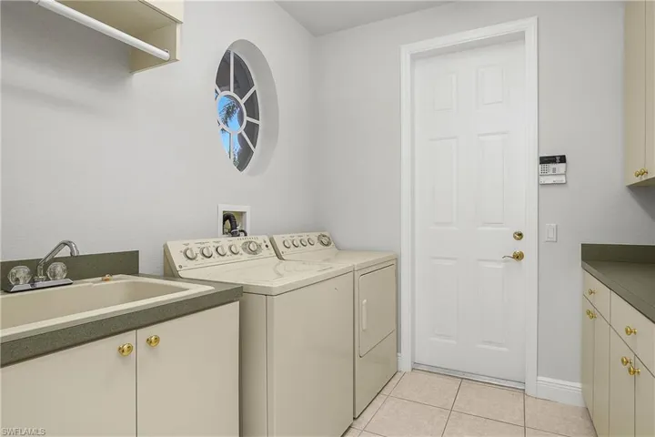 Indoor laundry tub, custom cabinets, washer and dryer convey with purchase price. Door leads to oversized 2-car garage.
