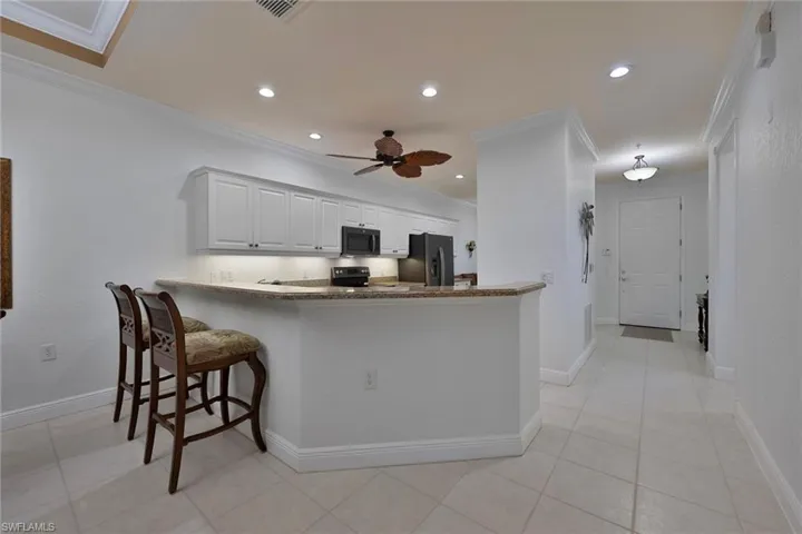Kitchen with appliances with stainless steel finishes, ornamental molding, recessed lighting, ceiling fan, and a peninsula
