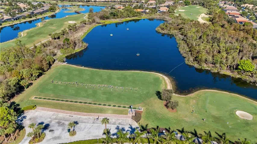 Aerial overview of property's location with a large body of water, nearby suburban area, and a golf club