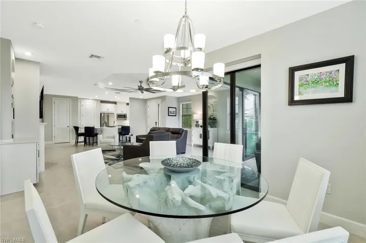 Dining space with a chandelier, a raised ceiling, and a ceiling fan
