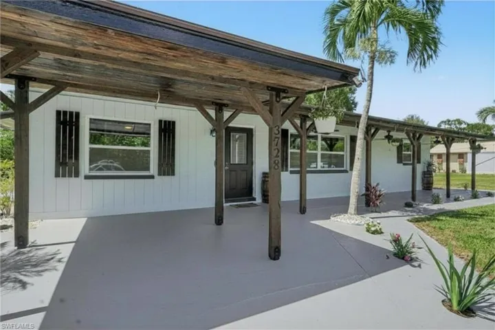 3728 Gasparilla St - Carport and Porch with gorgeous coastal plank wood ceiling crowns the porch boasting  3 ceiling fans and LED lighting added for enjoyment.