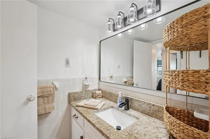 Bathroom featuring vanity, tile walls, and wainscoting