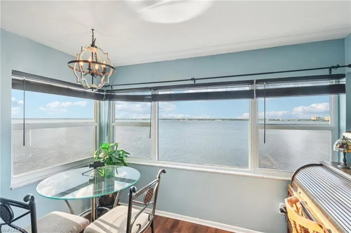 Sunroom featuring wood finished floors, plenty of natural light, and a water view