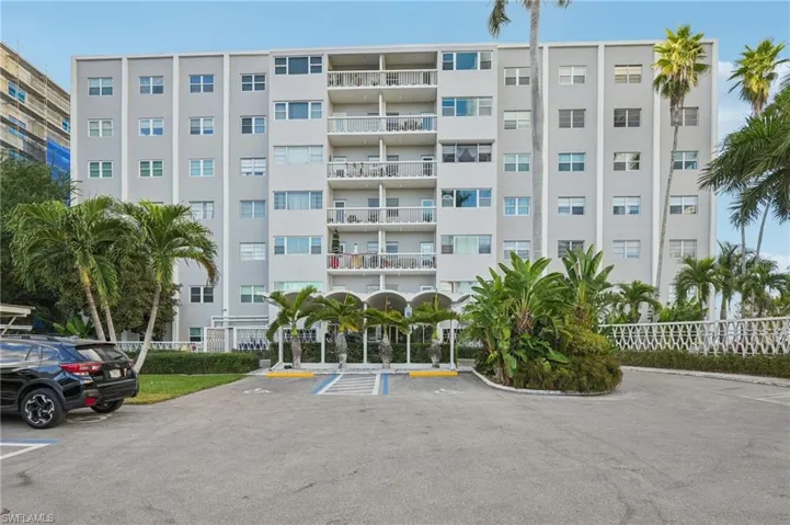 View of apartment building / complex featuring uncovered parking