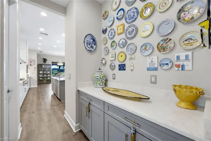 Custom cabinetry with light gray finish, polished hardware, and white countertops