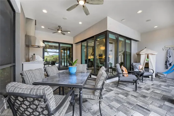 Expansive screened patio featuring wood-finish tile flooring, recessed lighting, and ceiling fans